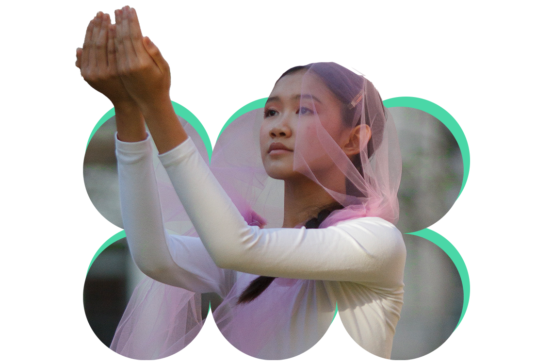 A cutout image of a dancer popping out of a fun, modern shape. She wears a pink veil-like headpiece, and is gesturing forward with both arms, hands cupped together.