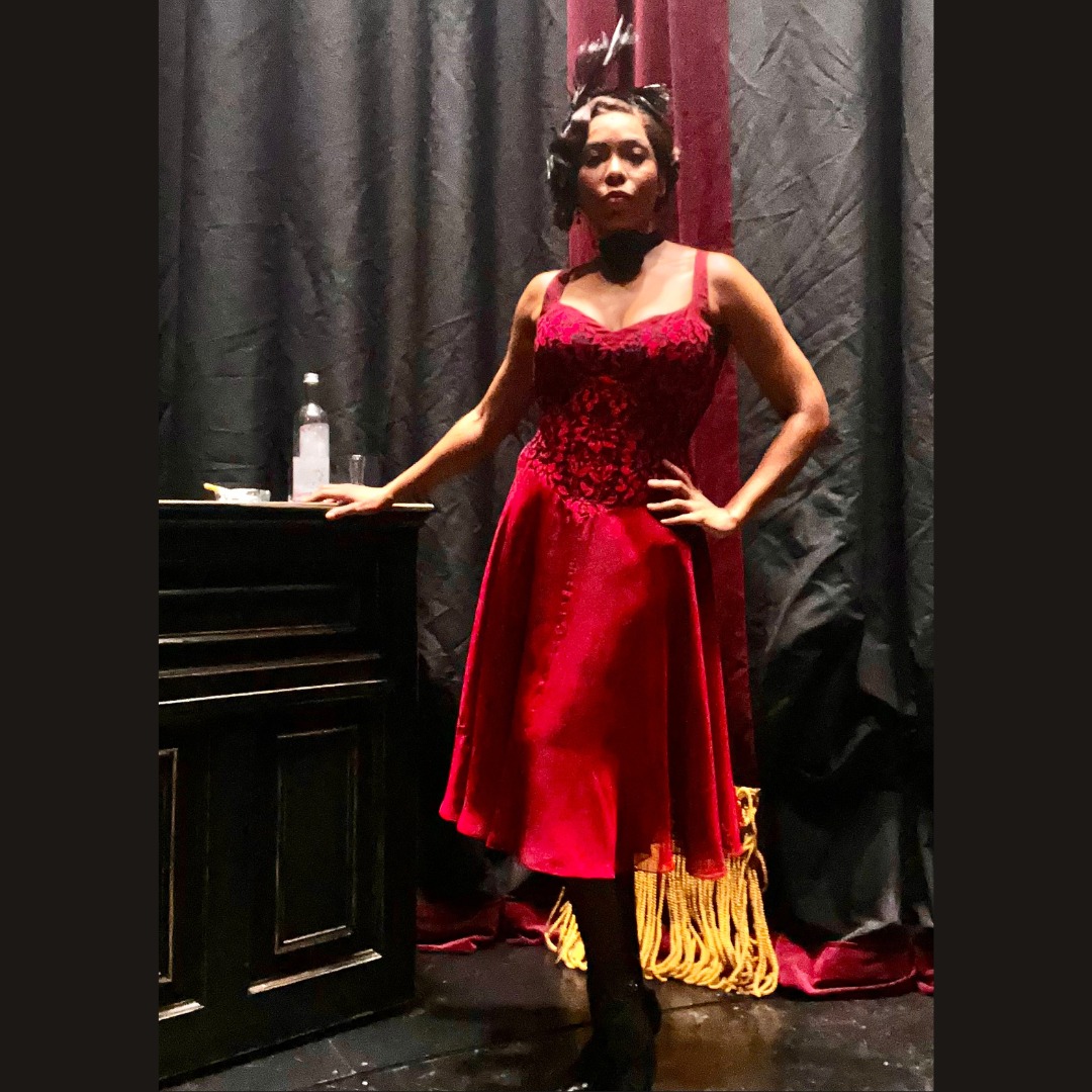 Dionne Figgins wears a red dress and feather headpiece while posing backstage. She plays Daisy Parker in the Louis Armstrong Broadway musical, "A Wonderful World."