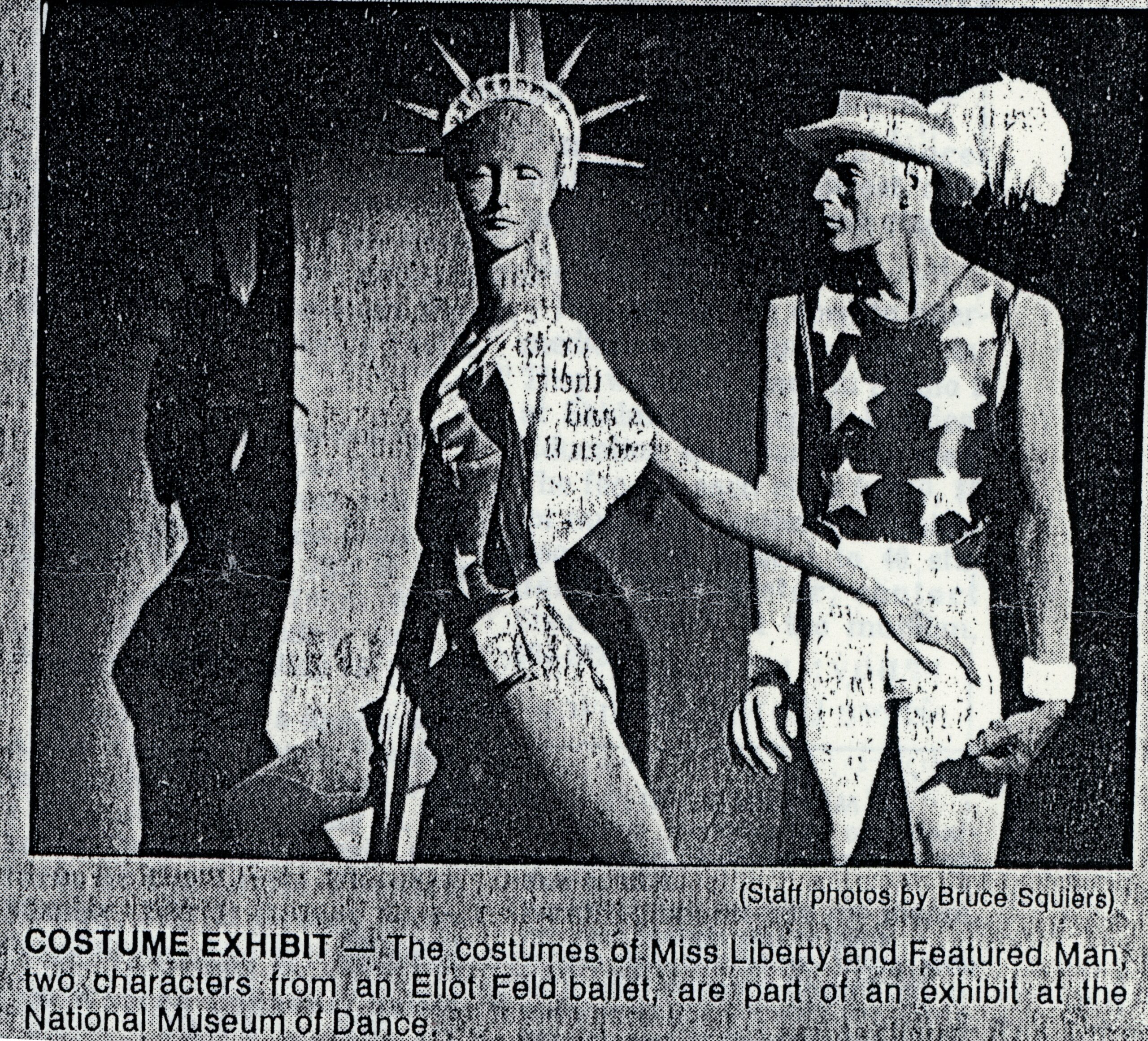 Scan of a newspaper clipping with a photo of the costume exhibit for Miss Liberty and Featured Man, two characters from Eliot Feld&#039;s &quot;Half Time.&quot;