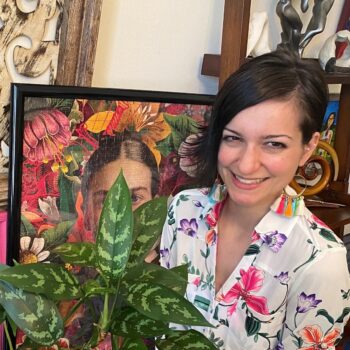 Headshot of Assistant Principal Georgia Giannikouris, smiling in a room with paintings and a plant.